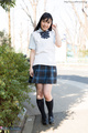 Student outdoors wearing uniform in plaid skirt wearing socks