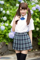 Student in uniform playing with her pigtails wearing pleated skirt