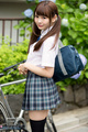 Atomi shuri standing beside bicycle hair in pigtails holding school bag