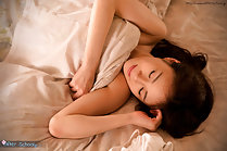 Kitagawa Yuzu under covers naked arm folded across her chest